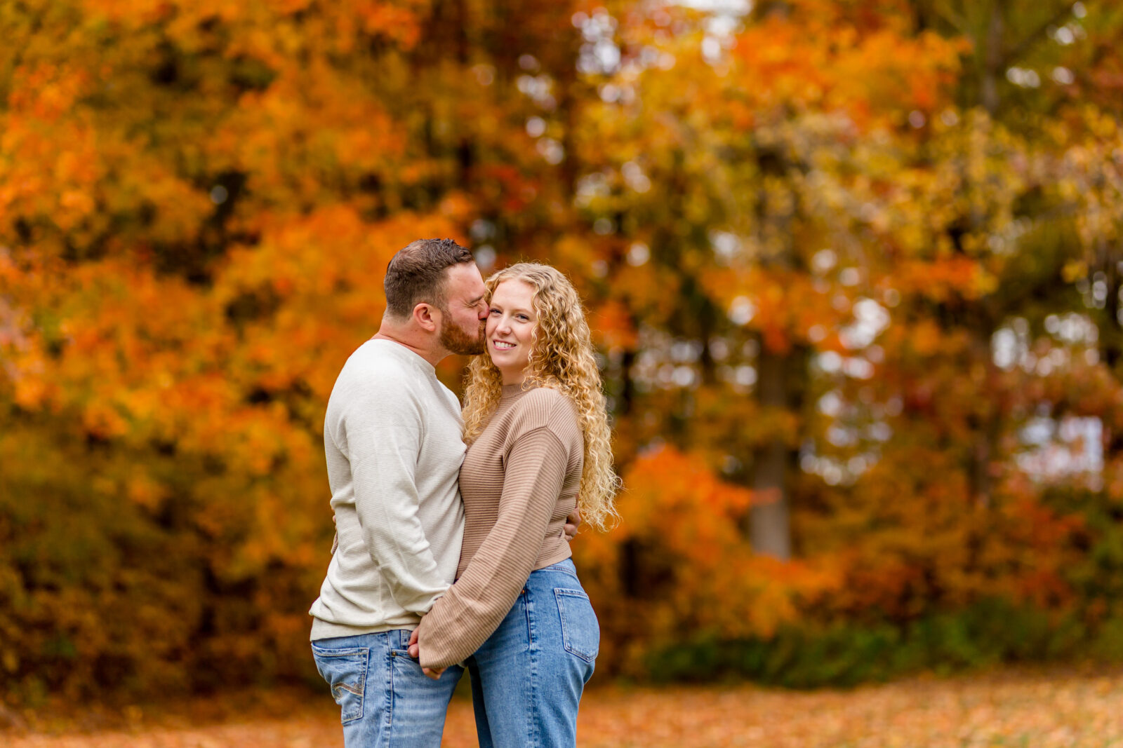 Forehead kiss in Otterville engagement session with fall leaves