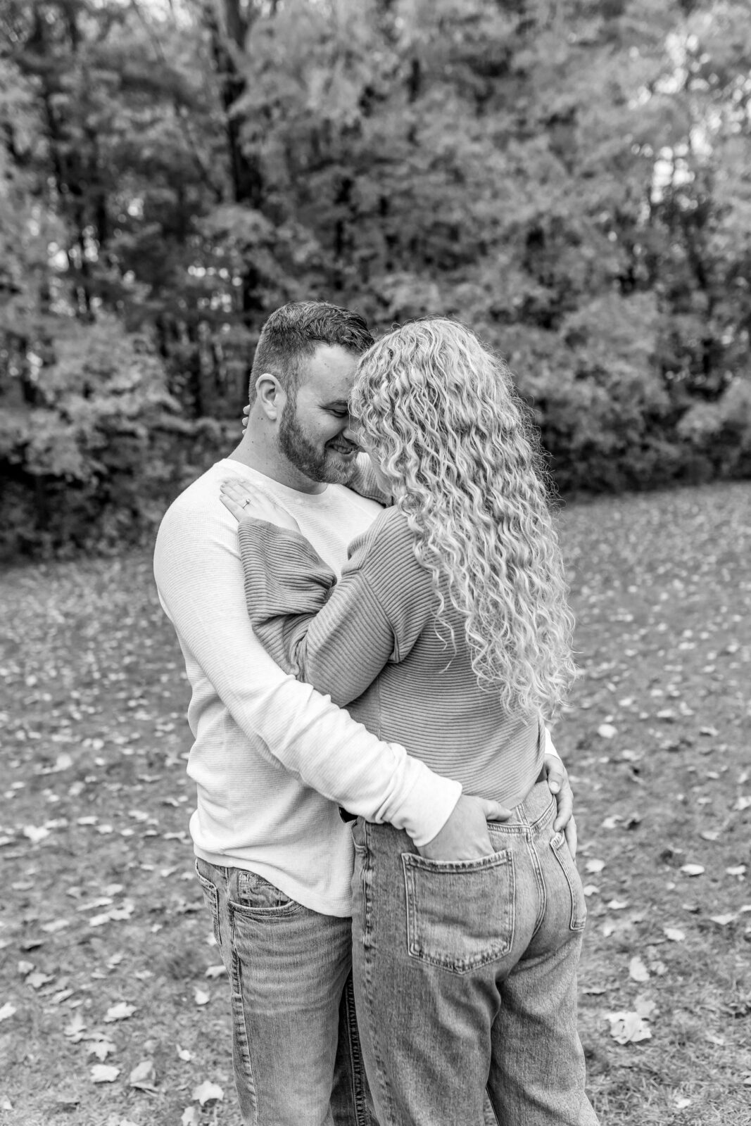 Cassie and Derrick smiling at each other during engagement session in Otterville